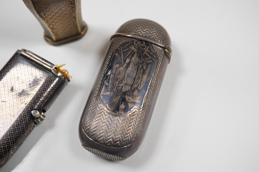 A 19th century continental engine turned parcel gilt white metal vesta case, 66mm, (lion head mark), together with two late 19th century continental white metal and niello vesta cases, one decorated with game.